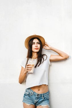 Kahve ve beyaz duvarın arkasında, kopya alanı ile şapkalı güzel esmer kız