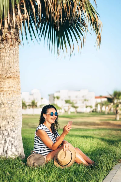 Bastante pan asiático turista chica sentado bajo la palmera y nosotros — Foto de Stock