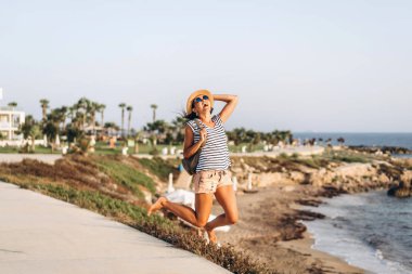 Sevimli turist pan Asya kız denize yakın açık atlama.