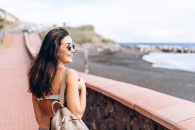 Esmer güzel uzun saçlı kız siyah s ile Sahilde yürüyüş