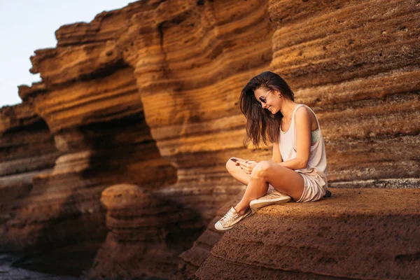 Piuttosto lunghi capelli bruna turista ragazza rilassante sulle pietre ne — Foto Stock