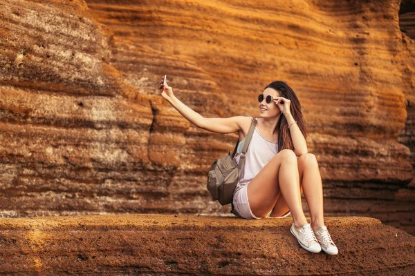 Красивая длинноволосая брюнетка-туристка отдыхает на камнях — стоковое фото