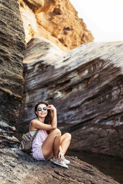 Bastante largo pelo morena turista chica relajarse en las piedras ne —  Fotos de Stock