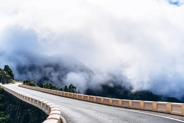 Strada vuota alta in montagna con cielo nebbioso nuvoloso . — Foto Stock
