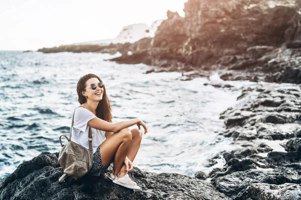 Docela dlouhý vlasy turistické dívka relaxační na kameny u moře. — Stock fotografie