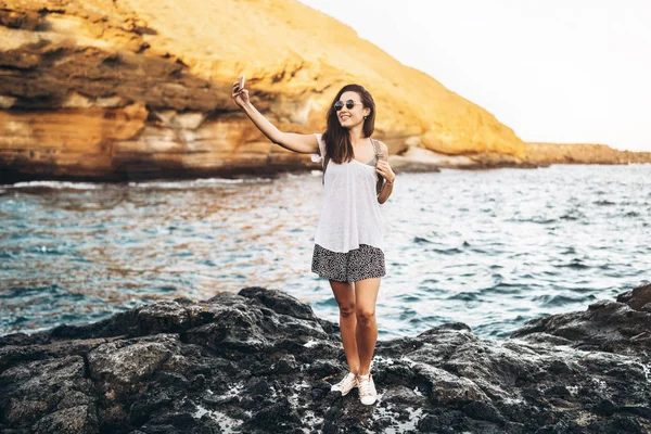 Piuttosto lunghi capelli ragazza turistica rilassante sulle pietre vicino al mare wi — Foto Stock