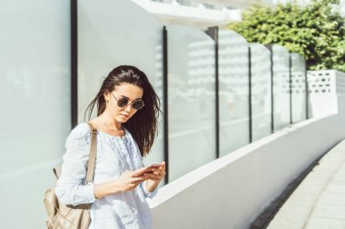 Güzel esmer kız akıllı telefon kullanarak açık.