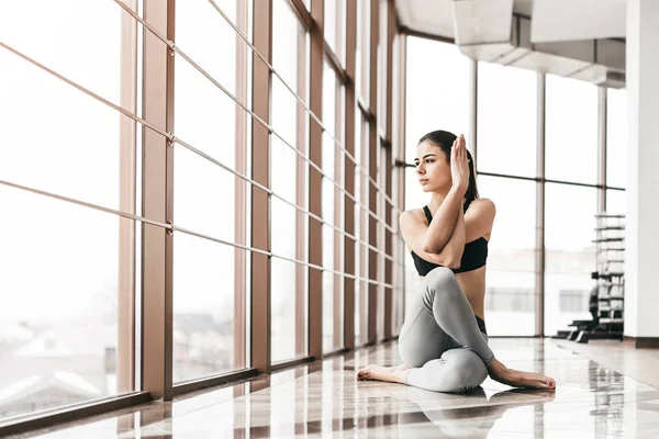 Jonge slanke aantrekkelijke vrouw met lang haar praktizerende yoga indoor — Stockfoto