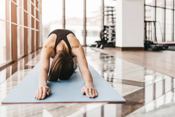 Jonge slanke aantrekkelijke vrouw met lang haar praktizerende yoga indoor — Stockfoto