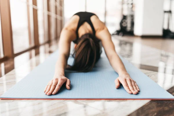 Jonge slanke aantrekkelijke vrouw met lang haar praktizerende yoga indoor — Stockfoto