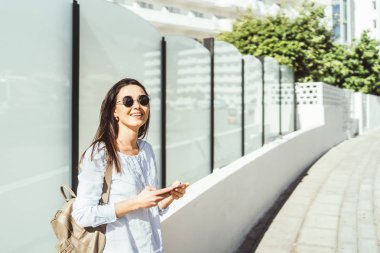 Güzel esmer kız akıllı telefon kullanarak açık.