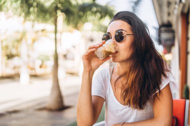 Oldukça uzun saçlı esmer kız sokak kafede kahve keyfini çıkarın.