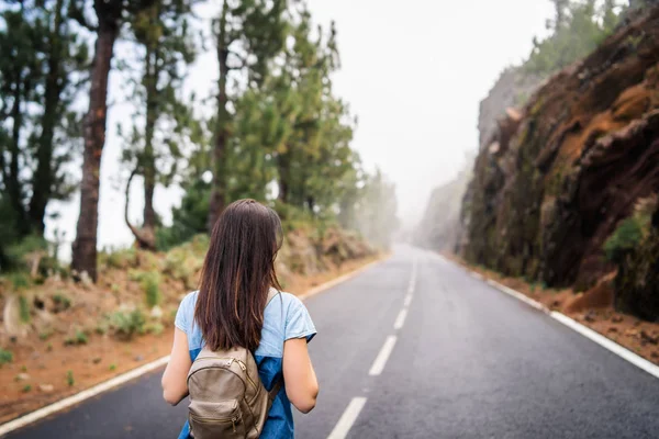 Achteraanzicht van lange haren brunette meisje lopen op de mistige weg ik — Stockfoto