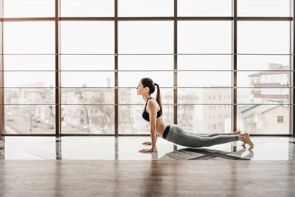 Jonge slanke aantrekkelijke vrouw met lang haar praktizerende yoga indoor — Stockfoto