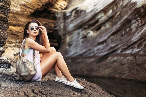 Bastante longo cabelo morena turista menina relaxante sobre as pedras ne — Fotografia de Stock