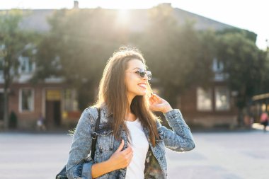 Güzel gülümseyen esmer kız sokakta yürüyüş.