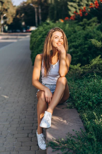 Pretty young smiling brunette girl relaxing outdoor on the stree — Stock Photo, Image