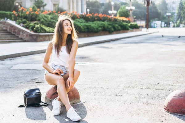 Mooie jonge glimlachende brunette meisje ontspannen buiten op de Stree — Stockfoto