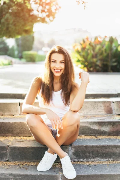 Pretty young smiling brunette girl relaxing outdoor on the stree — Stock Photo, Image