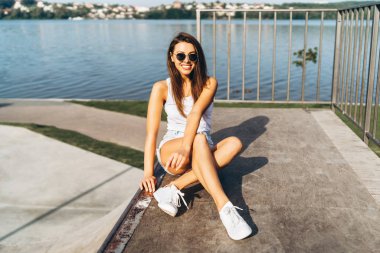 Uzun saçlı güzel genç esmer kız açık havada rahatlatıcı