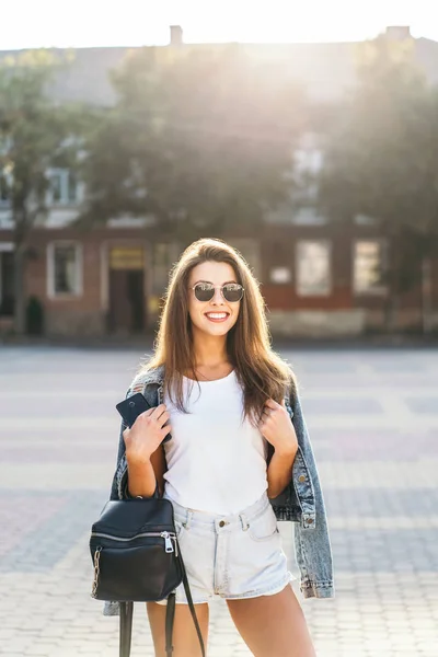 Pěkná usměvavá brunetka, která chodí po ulici. — Stock fotografie