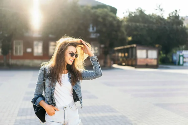 Pěkná usměvavá brunetka, která chodí po ulici. — Stock fotografie