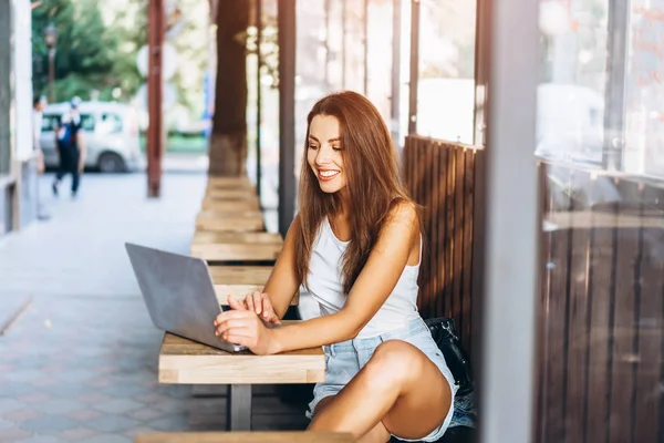 Pretty jong meisje werkt op laptop in Street Cafe outdoor. — Stockfoto