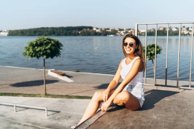 Uzun saçlı güzel genç esmer kız açık havada rahatlatıcı