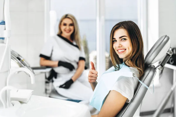 Pretty young female dentist making examination and treatment for — Stock Photo, Image