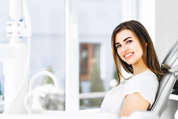 Pretty happy and smiling dental patient sitting in the dental ch — Stock Photo, Image