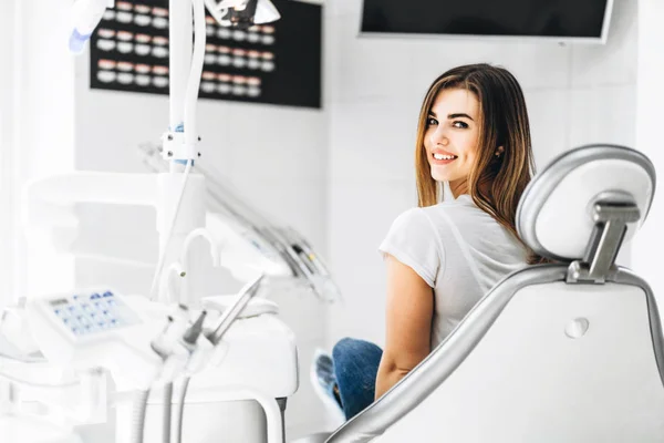 Pretty happy and smiling dental patient sitting in the dental ch — Stock Photo, Image