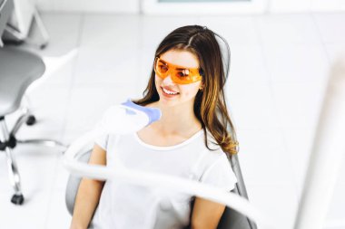 Diş beyazlatma prosedürü oldukça mutlu kadın hasta için bir d