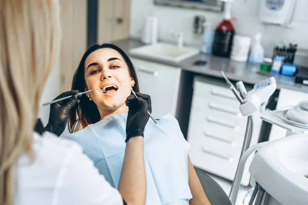 Bastante jovem dentista fazendo exame e tratamento para — Fotografia de Stock