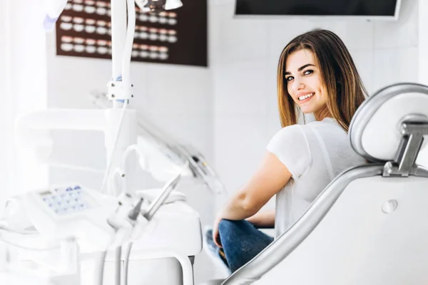 Pretty happy and smiling dental patient sitting in the dental ch — Stock Photo, Image