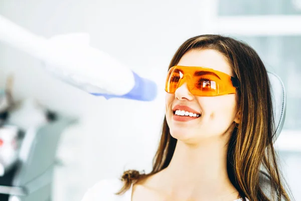 Tandblekning förfarande för ganska lycklig kvinnlig patient i en d — Stockfoto