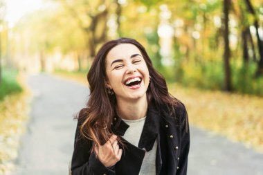 Parkta rahatlatıcı Oldukça uzun saçlı esmer kız, sonbahar zamanı