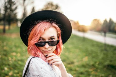 Parkta rahatlatıcı kırmızı saçlı ve şapka ile Pretty kız, sonbahar t