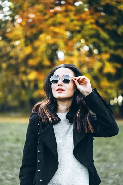 Досить довге волосся брюнетка дівчина розслабляється в парку, осінній час — стокове фото
