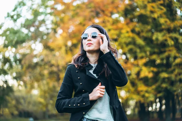 Piuttosto lunghi capelli ragazza bruna rilassante nel parco, tempo d'autunno — Foto Stock