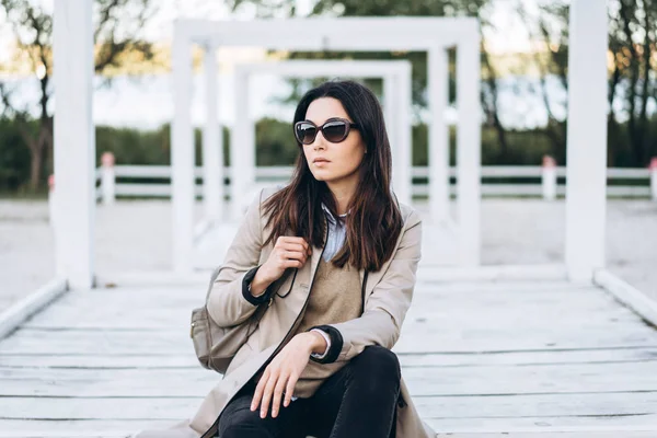 Mooie lange haren brunette meisje in zonnebril ontspannen buiten. — Stockfoto