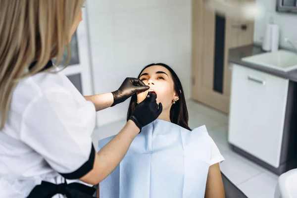 Oldukça genç kadın dişçi muayene ve tedavi yapma — Stok fotoğraf