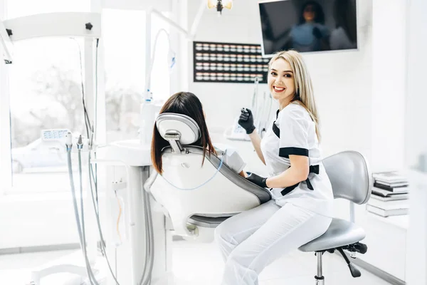 Hübsche junge Zahnärztin macht Untersuchung und Behandlung für — Stockfoto