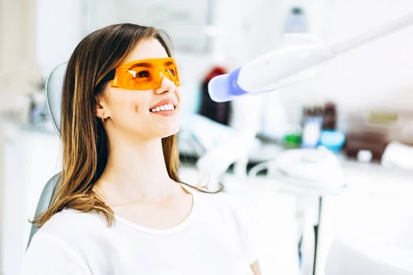 Teeth whitening procedure for pretty happy female patient in a d — Stock Photo, Image