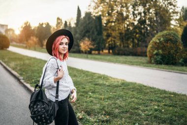 Parkta rahatlatıcı kırmızı saçlı ve şapka ile Pretty kız, sonbahar t