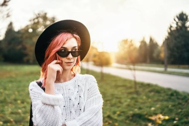 Parkta rahatlatıcı kırmızı saçlı ve şapka ile Pretty kız, sonbahar t