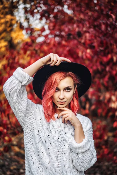 Красива дівчина з рудим волоссям і капелюхом, що йде в парку, осінь — стокове фото