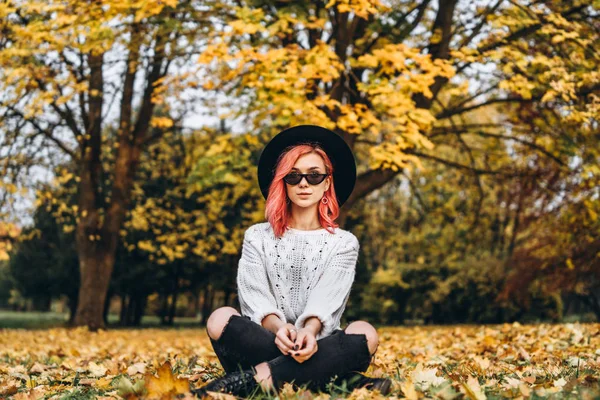 Chica bonita con el pelo rojo y sombrero relajante en el parque, t otoño — Foto de Stock