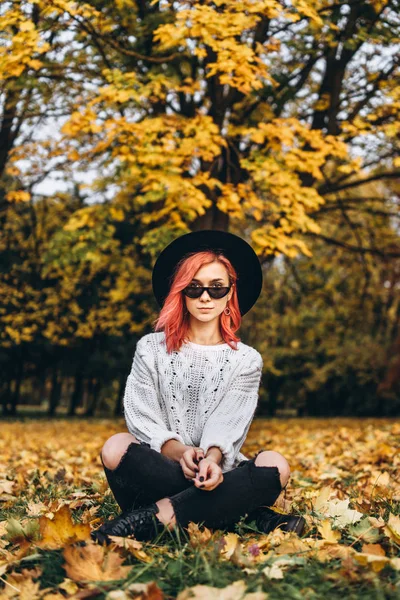 Chica bonita con el pelo rojo y sombrero relajante en el parque, t otoño — Foto de Stock