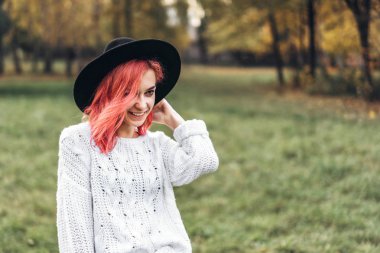 Parkta rahatlatıcı kırmızı saçlı ve şapka ile Pretty kız, sonbahar t