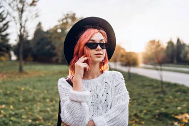 Parkta rahatlatıcı kırmızı saçlı ve şapka ile Pretty kız, sonbahar t